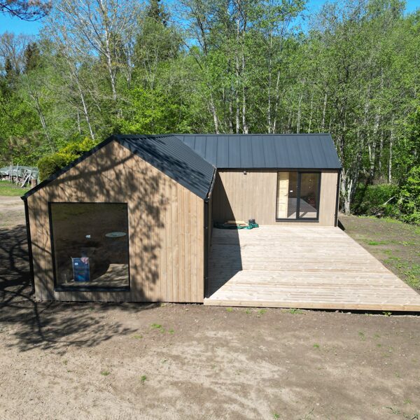 Karkasinis namas su terasa ir langais – pilnas fasado vaizdas iš šono