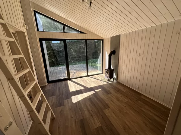 Svetainė su kieto kuro krosnele – jaukus karkasinio namo interjeras su balintų dailylenčių