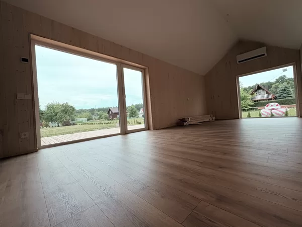 Langas į terasą ir grindų apdaila – L formos karkasinio namo svetainės/virtuvės zonoje